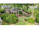 Aerial view of a backyard with a stone patio, fire pit, pergola, and lush landscaping at 295 Sagamore Nw Cv, Sugar Hill, GA 30518