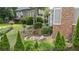 Backyard patio with a fire pit and stone bench sitting area with lush trees and plants at 295 Sagamore Nw Cv, Sugar Hill, GA 30518