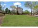 Expansive backyard featuring a well-maintained lawn, mature trees, and manicured landscaping at 295 Sagamore Nw Cv, Sugar Hill, GA 30518