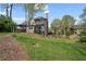 Charming home boasts a spacious backyard with a lush green lawn and mature trees at 295 Sagamore Nw Cv, Sugar Hill, GA 30518