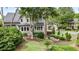 Backyard stone patio with a fire pit and stone bench sitting area surrounded by lush plants and trees at 295 Sagamore Nw Cv, Sugar Hill, GA 30518