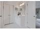 Classic white bathroom with double doors, single vanity, and ample storage space at 295 Sagamore Nw Cv, Sugar Hill, GA 30518
