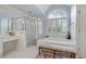 Bright bathroom with a walk-in shower, soaking tub, and arched window with shuttered blinds at 295 Sagamore Nw Cv, Sugar Hill, GA 30518