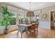 Charming dining room with a rustic table, hardwood floors, and natural light from the surrounding windows at 295 Sagamore Nw Cv, Sugar Hill, GA 30518