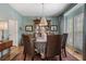 Dining room with wainscoting, elegant light fixture, neutral colored walls, and woven dining chairs at 295 Sagamore Nw Cv, Sugar Hill, GA 30518
