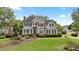 Beautiful two-story home with a well-manicured lawn, mature trees, and a classic front facade at 295 Sagamore Nw Cv, Sugar Hill, GA 30518