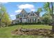 Charming two-story home featuring manicured landscaping, gray siding, and black shutters under a partly cloudy sky at 295 Sagamore Nw Cv, Sugar Hill, GA 30518