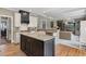Open-concept kitchen showcasing an island, stainless steel appliances, and seamless flow to living area at 295 Sagamore Nw Cv, Sugar Hill, GA 30518
