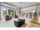 Open-concept living room with large windows, comfortable seating, and easy access to the dining area at 295 Sagamore Nw Cv, Sugar Hill, GA 30518