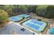 Aerial view of tennis courts surrounded by mature trees, parking lot, and amenities, perfect for sports enthusiasts at 295 Sagamore Nw Cv, Sugar Hill, GA 30518