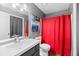 Charming bathroom with red shower curtain, vanity, and ample lighting at 4695 Waters Rd, Woodstock, GA 30188