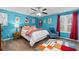 Colorful bedroom offers bright blue walls, modern decor and a comfortable queen-sized bed at 4695 Waters Rd, Woodstock, GA 30188