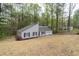 Exterior view of home featuring a gray facade, red door, and a three car garage at 4695 Waters Rd, Woodstock, GA 30188