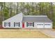 Charming single-story home with light gray siding, black shutters, and a red front door at 4695 Waters Rd, Woodstock, GA 30188