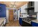 Stylish kitchen features wood ceilings, stainless steel appliances and bold blue cabinetry at 4695 Waters Rd, Woodstock, GA 30188