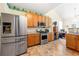 Well-lit kitchen featuring stainless steel appliances, light wood cabinets, and tile flooring at 545 Goldfinch Way, Stockbridge, GA 30281