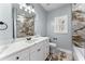 Well-lit bathroom features a marble tiled shower, white vanity with ample storage, and updated fixtures at 6091 Wayfarer Dr, Villa Rica, GA 30180
