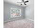 Cozy bedroom featuring a ceiling fan and view of the outdoors through the windows at 6091 Wayfarer Dr, Villa Rica, GA 30180