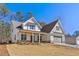 Beautiful two-story home showcasing white siding, a welcoming covered porch, and a spacious driveway at 6091 Wayfarer Dr, Villa Rica, GA 30180