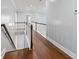 Hallway with dark wood floors and railing leading upstairs at 6091 Wayfarer Dr, Villa Rica, GA 30180