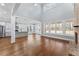 Expansive living room featuring hardwood floors, high ceilings, a brick fireplace, and an open kitchen at 6091 Wayfarer Dr, Villa Rica, GA 30180