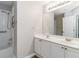 Bathroom with white vanity, double sinks, and a shower with accessibility features at 7415 Marina Cv, Stone Mountain, GA 30087