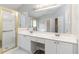 Bathroom with double vanity, a large mirror, and a shower with gold trim at 7415 Marina Cv, Stone Mountain, GA 30087