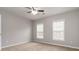 Spacious bedroom featuring two windows and neutral carpet at 7415 Marina Cv, Stone Mountain, GA 30087