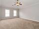 Spacious bedroom with neutral carpeting, ceiling fan, and two windows providing natural light at 7415 Marina Cv, Stone Mountain, GA 30087