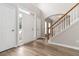 Bright entryway with hardwood floors, a staircase with white banister, and a view of the front door at 7415 Marina Cv, Stone Mountain, GA 30087