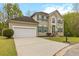 Lovely two-story home with a driveway, a two-car garage, green shutters, and manicured landscaping at 7415 Marina Cv, Stone Mountain, GA 30087