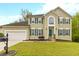 Charming two-story home featuring a well-manicured lawn, attached garage, and complementary green window shutters at 7415 Marina Cv, Stone Mountain, GA 30087
