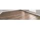 New hardwood flooring brightens a room with window and white molding details, enhancing the property's interior at 7415 Marina Cv, Stone Mountain, GA 30087