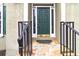 Inviting front entrance with stone steps, a sturdy black railing, and a solid green front door at 7415 Marina Cv, Stone Mountain, GA 30087