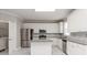 Modern kitchen with stainless steel appliances, granite countertops, and ample cabinet space and laundry room at 7415 Marina Cv, Stone Mountain, GA 30087