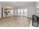 Spacious living room with hardwood floors, a fireplace, and an open view into the adjacent kitchen at 7415 Marina Cv, Stone Mountain, GA 30087