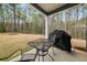 Enjoy the outdoors on the covered patio with a table, chairs and grill with serene forest views at 1037 Devon Dr, Acworth, GA 30102