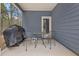 The covered back patio has an outdoor grill and furniture overlooking the trees and greenery at 1037 Devon Dr, Acworth, GA 30102