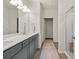Modern bathroom features double vanity, sleek gray cabinets, a glass-enclosed shower, and wood-look flooring at 1037 Devon Dr, Acworth, GA 30102