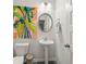 This stylish powder room has a pedestal sink, decorative mirror, and modern artwork at 1037 Devon Dr, Acworth, GA 30102