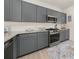 Features modern grey cabinets, granite countertops, stainless steel appliances, and subway tile backsplash at 1037 Devon Dr, Acworth, GA 30102