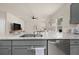 Bright kitchen with gray cabinets, granite countertops, and stainless steel dishwasher with an adjacent living space at 1037 Devon Dr, Acworth, GA 30102
