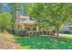 Inviting home exterior with a stone chimney, covered porch, manicured landscaping and lush green lawn at 1714 Parkhill Dr, Decatur, GA 30032
