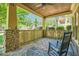 Cozy front porch with stone columns, wood railings, ceiling fan, and comfortable seating with a rocking chair at 1714 Parkhill Dr, Decatur, GA 30032