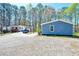 Exterior shot showing a gravel driveway, white house with front porch, and blue house at 5955 Kemp Dr, Acworth, GA 30102