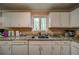 Well-lit kitchen sink area with granite countertops and white cabinetry, offering garden view at 5955 Kemp Dr, Acworth, GA 30102