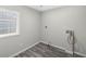 A modern laundry room featuring gray wood-look flooring, white walls, and utility connections at 5955 Kemp Dr, Acworth, GA 30102