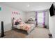 Cozy bedroom featuring carpeted floors, a bed with a colorful comforter, and a large window at 89 Cowpen Ct, Covington, GA 30014