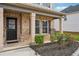 Inviting covered front porch with brick columns and manicured landscaping at 89 Cowpen Ct, Covington, GA 30014