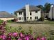 A spacious backyard showing the home's rear elevation and blooming azalea bushes at 9450 Knollcrest Blvd, Alpharetta, GA 30022